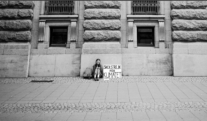 Greta Thunberg, aged 15, sits outside of Swedish Parliament in 2018 during the first solo school climate strike. A year later she's created a worldwide movement with millions.