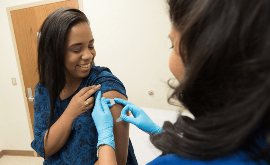 An image of a health worker giving a vaccination to introduce an article on COVID-19 vaccination