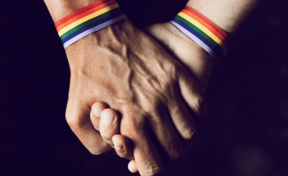 hands with pride bracelets to introduce an article about when LGBTQ+ identity gets seen as a battleground