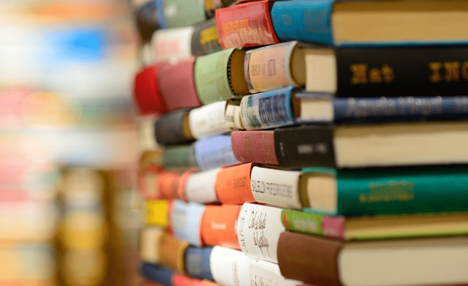 Rainbow stack of books to introduce an article encouraging people to read banned books, especially about LGBTQ+ identities