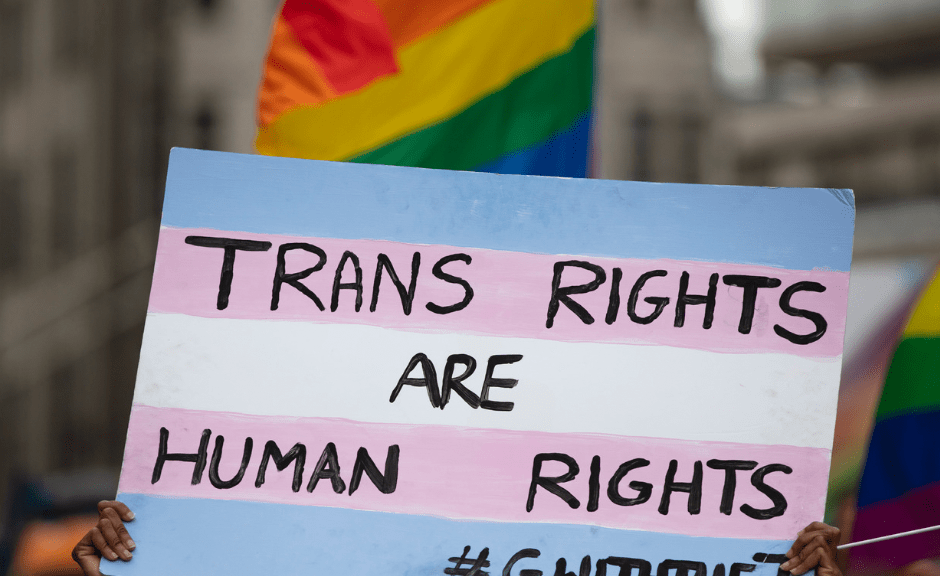 a sign that says "trans rights are human rights" to introduce an article on an unprecented wave of anti-trans legislation in 2023